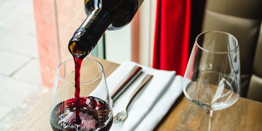 Bon sommelier qui sert un verre de vin rouge dans un restaurant