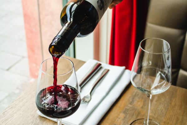 Bon sommelier qui sert un verre de vin rouge dans un restaurant