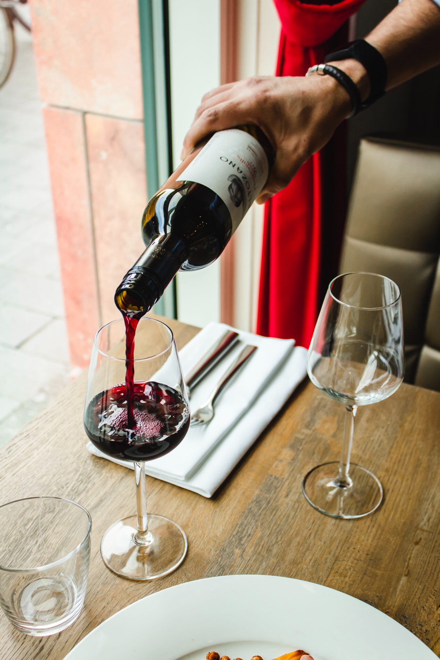 Bon sommelier qui sert un verre de vin rouge dans un restaurant